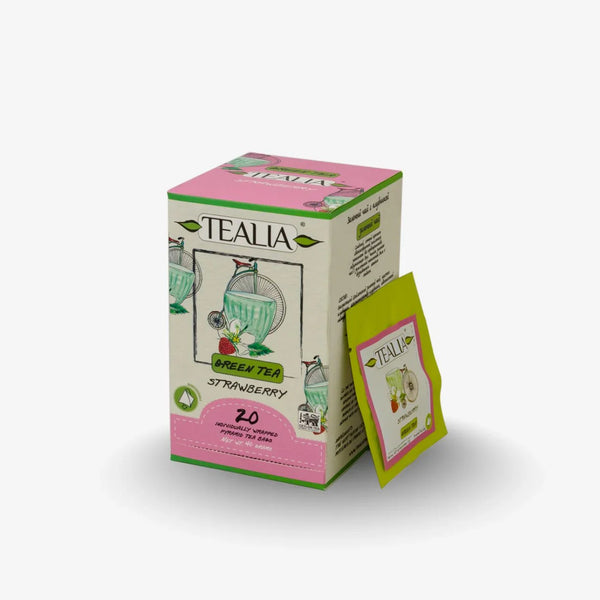Box of Tealia strawberry green tea with a single wrapped tea bag, on white background