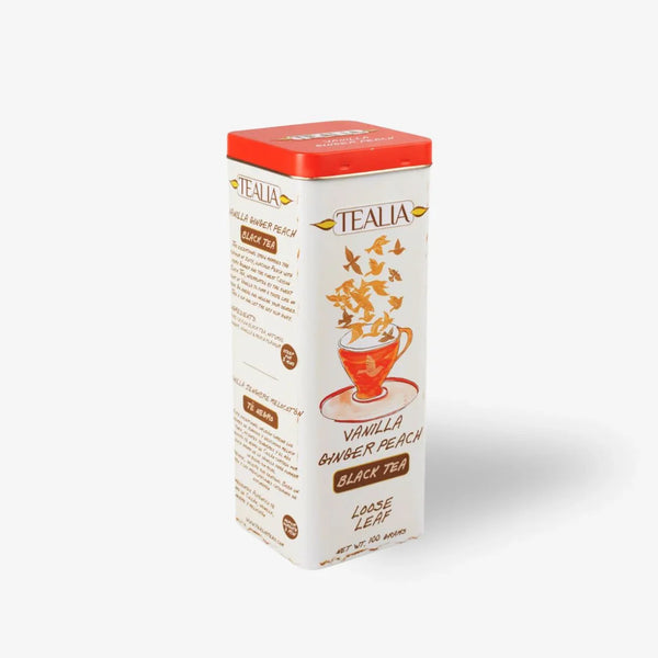 Rectangular tin of vanilla ginger peach black tea loose leaf with red lid and illustrated tea cup.